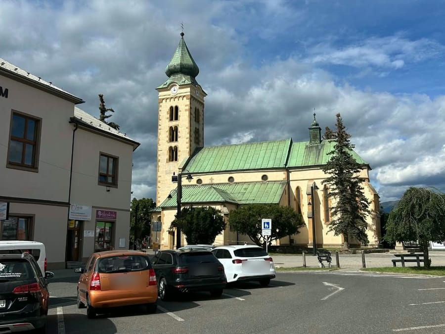 Parkovisko na námestí pri budove Liptáčik, v pozadí kostol
